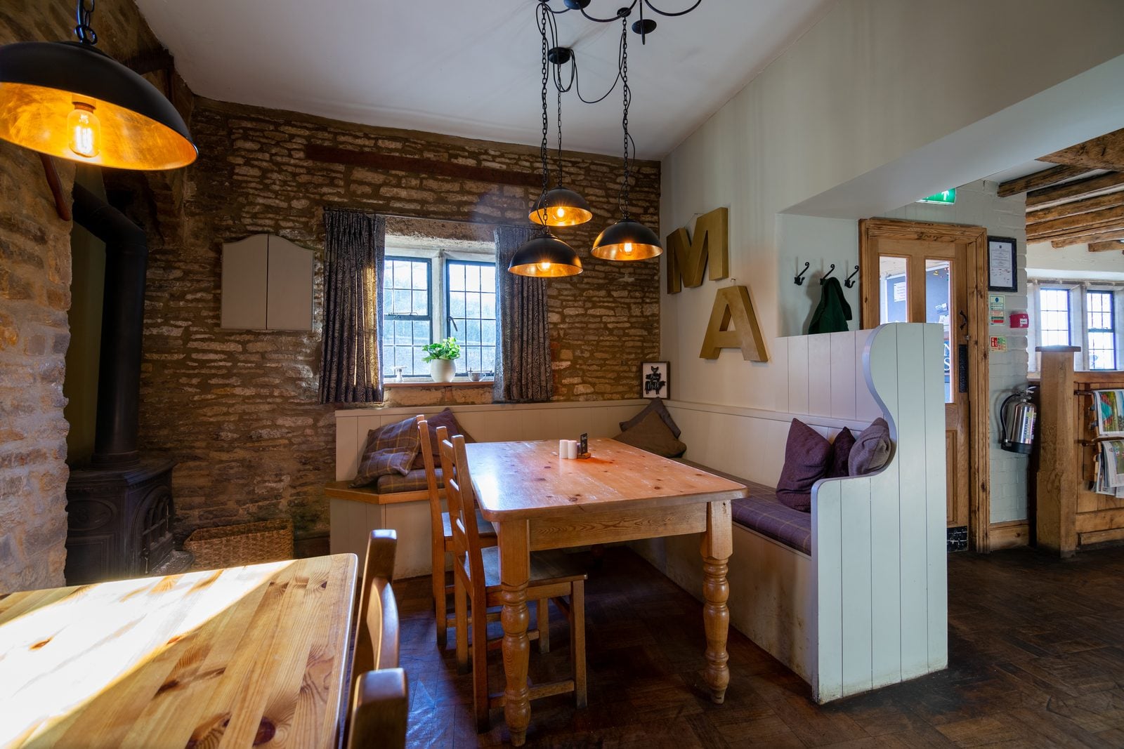 Dining area with pendant lights and stone wall